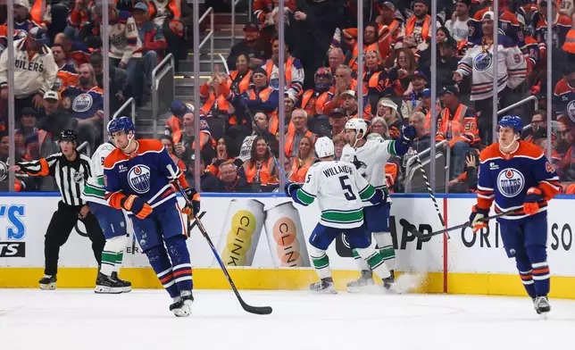 Vancouver Canucks' Tom Willander (5) and Paul Cotter (47) celebrate Cotter's game-winning goal against the Edmonton Oilers during overtime NHL hockey action in Edmonton on Tuesday, Sept. 29, 2026. (Codie McLachlan/The Canadian Press via AP)