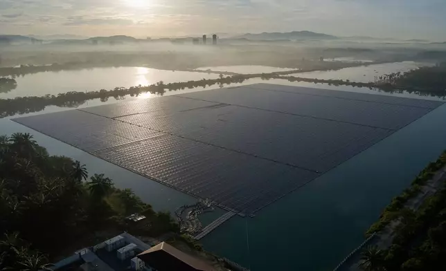 FILE- The sun rises over floating solar panels on May 3, 2023, in Selangor, Malaysia. (AP Photo/Vincent Thian, File)