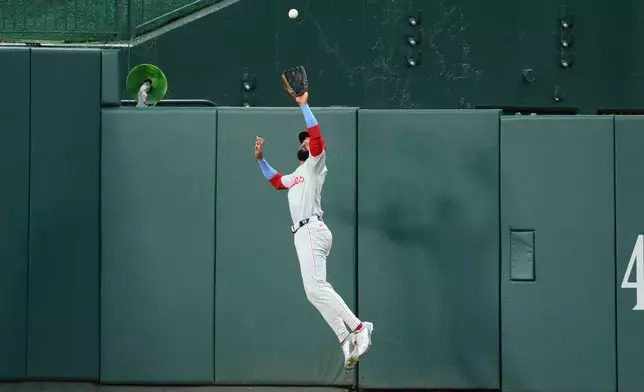 Philadelphia Phillies center fielder Derek Hill leaps up to make a catch on a fly ball by Washington Nationals' Dylan Crews for an out during the first inning of a baseball game, Tuesday, Sept. 15, 2026, in Washington. (AP Photo/Nick Wass)
