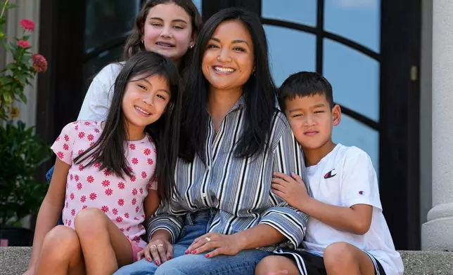 Monette Wagner poses with her children, Vivienne, 12, top left, Ellie, 9, left, and Xavier, 7, at her home her home in Indianapolis, Ind., Tuesday, Aug. 18, 2026. (AP Photo/Michael Conroy)