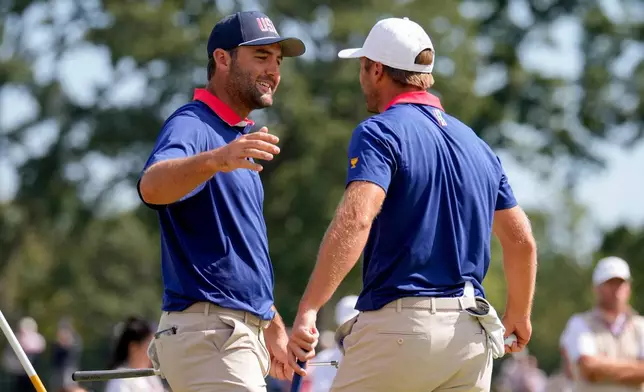 USA teams' Sam Burns, right, hugs Scottie Scheffler after defeating the International team in their Presidents Cup golf tournament third round four-ball match at Medinah Country Club, Saturday, Sept. 26, 2026, in Medinah, Ill. (AP Photo/Matt Slocum)