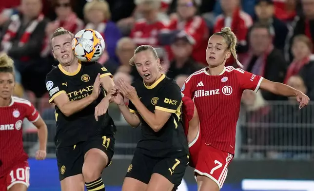Bayern's Giulia Gwinn, right, collides with Manchester City's Beth Mead and Lauren Hemp, left, during the women's Champions League opening phase soccer match between FC Bayern Munich and Manchester City in Munich, Germany, Tuesday, Sept. 22, 2026. (AP Photo/Matthias Schrader)