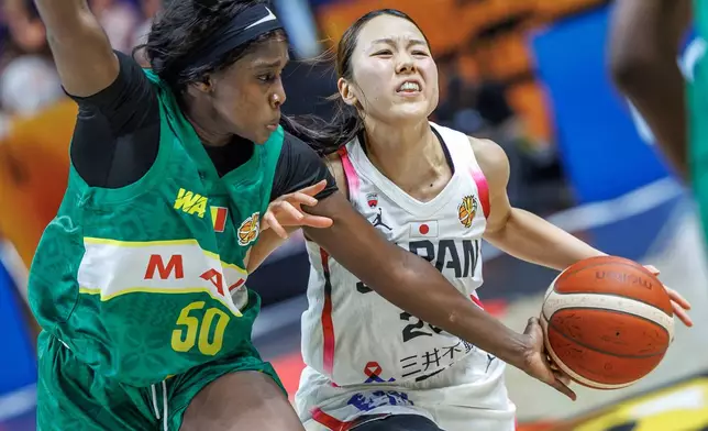 Japan's Mai Yamamoto, right, is challenged by Mali's Djeneba N Diaye during the women's World Cup basketball match between Mali and Japan, in Berlin Friday, Sept. 4, 2026. (Andreas Gora/dpa via AP)
