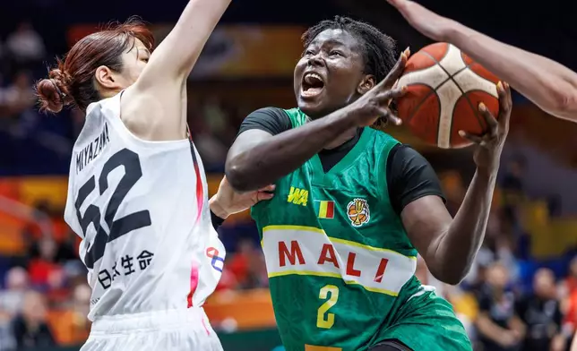 Mali's Aminata Sangare and Japan's Yuki Miyazawa vie for the ball during the women's World Cup basketball match between Mali and Japan, in Berlin Friday, Sept. 4, 2026. (Andreas Gora/dpa via AP)