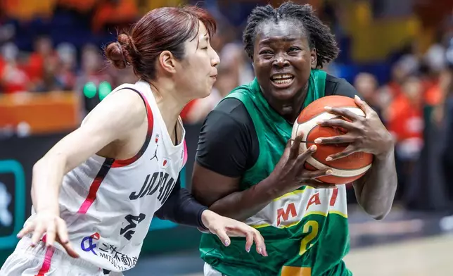 Mali's Aminata Sangare, right, and Japan's Yuki Miyazawa during the women's World Cup basketball match between Mali and Japan, in Berlin Friday, Sept. 4, 2026. (Andreas Gora/dpa via AP)