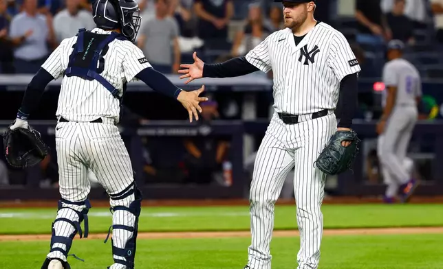 New York Yankees catcher Austin Wells, left, and pitcher David Bednar, right, shakes hands after defeating the Colorado Rockies, Tuesday, Sept. 8, 2026, in New York. (AP Photo/Noah K. Murray)