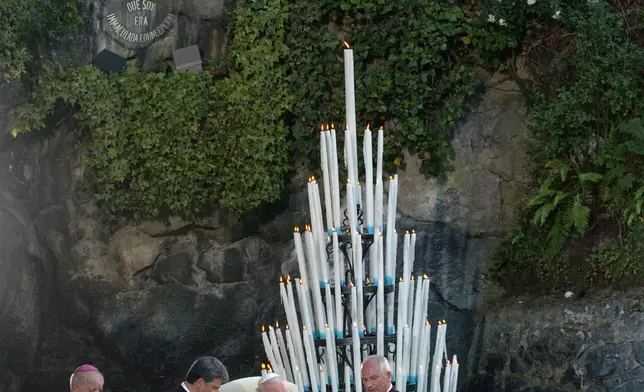 FILE - Pope John Paul II prays, at the Virgin Mary shrine cave prior to his departure to Rome in Lourdes, southwestern France, Sunday Aug. 15, 2004. (AP Photo/Christophe Ena, File)