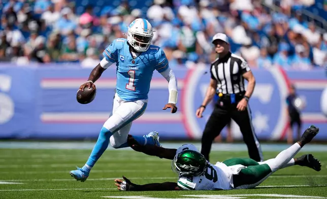 Tennessee Titans quarterback Cam Ward (1) scrambles past New York Jets defensive end Will McDonald IV (9) during the second half of an NFL football game, Sunday, Sept. 13, 2026, in Nashville, Tenn. (AP Photo/George Walker IV)