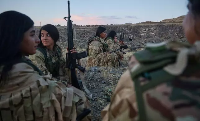 Fighters with the Kurdish Women's Protection Units, or YPJ, rest during a break in military training in the countryside of Derik, also known as al-Malikiyah, northeastern Syria, Saturday, Sept. 12, 2026.(AP Photo/Baderkhan Ahmad)