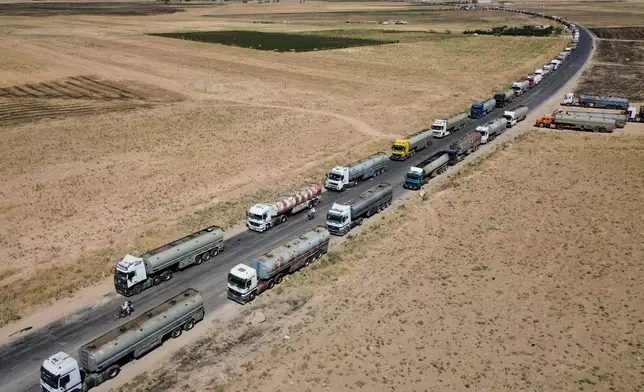 Oil tankers from the Rmeilan oil fields are backed up along a road after being stopped by local residents during ongoing protests against higher fuel prices near Tal Tamr in northeastern Syria, Wednesday, Sept. 16, 2026. (AP Photo/Baderkhan Ahmad)