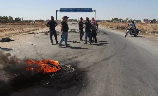Local residents block a road to prevent oil tankers from the Rmeilan oil fields from passing during ongoing protests against higher fuel prices at the entrance to Tal Tamr, northeastern Syria, Wednesday, Sept. 16, 2026. (AP Photo/Baderkhan Ahmad)