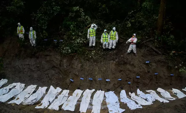 Nepal police personnel prepare the bodies of flash flood victims for a mass burial in Kathmandu, Nepal, Tuesday, Sept. 1, 2026. (AP Photo/Niranjan Shrestha)