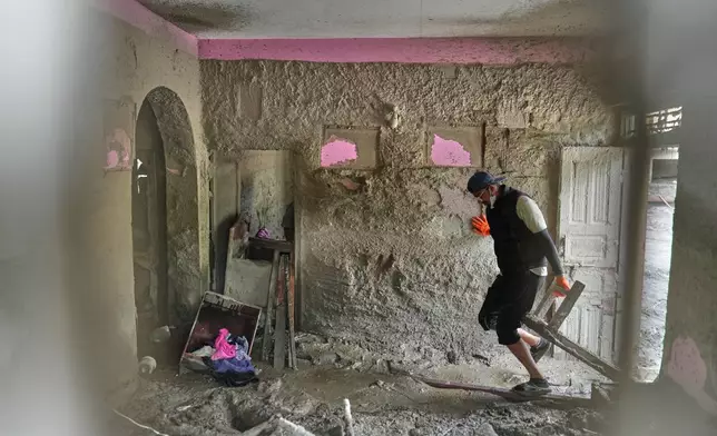 A resident salvages usable material from his house damaged by flash flooding at 1 Number Pul, in Nepal's Nuwakot district, Tuesday, Sept. 1, 2026. (AP Photo/Rajesh Kumar Singh)