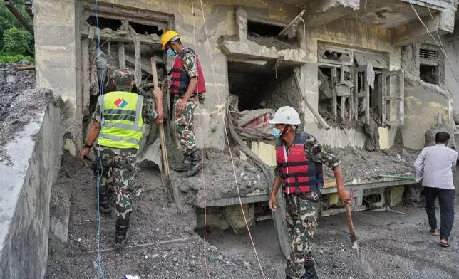 Rescuers inspect a residential building damaged in the aftermath of the flash floods in Nepal's Nuwakot district, Wednesday, Sept. 2, 2026. (AP Photo/Rajesh Kumar Singh)