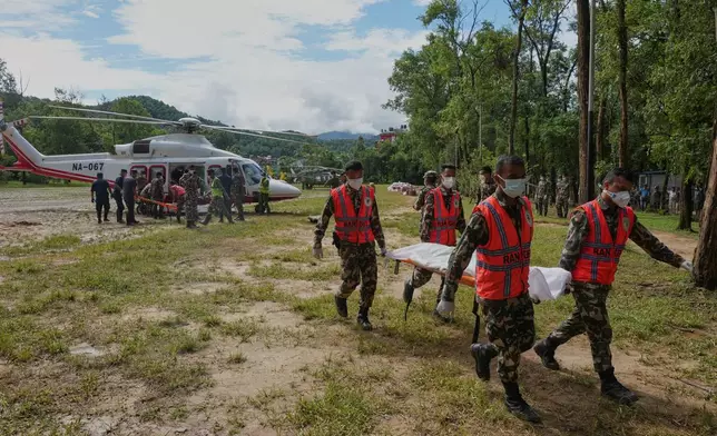 Nepal's army personnel carry a victim from the flash floods in a body bag at a helipad in an army camp in Nuwakot district, Nepal, Wednesday, Sept. 2, 2026. (AP Photo/Rajesh Kumar Singh)