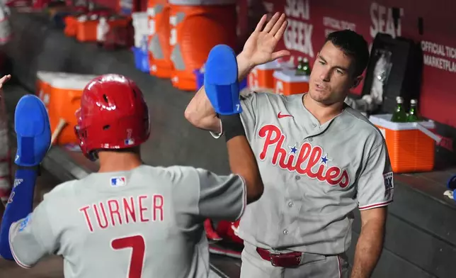 Philadelphia Phillies' Trea Turner (7) celebrates his run scored against the Arizona Diamondbacks with Phillies' J.T. Realmuto during the first inning of a baseball game, Tuesday, Sept. 1, 2026, in Phoenix. (AP Photo/Ross D. Franklin)