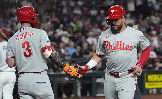 Philadelphia Phillies' Kyle Schwarber, right, celebrates his run scored against the Arizona Diamondbacks with Phillies' Bryce Harper (3) during the first inning of a baseball game, Tuesday, Sept. 1, 2026, in Phoenix. (AP Photo/Ross D. Franklin)