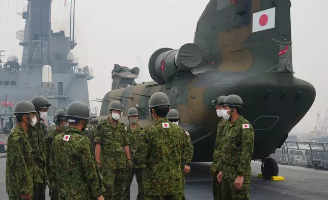 Crew members have a briefing near one of the Chinook helicopters which will be used to help battle forest fires on Kalimantan Island, on the deck of Japanese tank landing ship JS Kunisaki after its arrival at Kijing Port in Mempawah, West Kalimantan, Indonesia, Thursday, Sept. 10, 2026. (AP Photo/Tatan Syuflana)