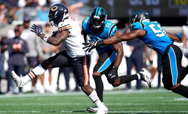 Chicago Bears running back D'Andre Swift (4) runs against Carolina Panthers linebacker Jeremiah Moon (56) and inside linebacker Bobby Okereke (58) to score a touchdown during the second half of an NFL football game, Sunday, Sept. 13, 2026, in Charlotte, N.C. (AP Photo/Erik Verduzco)