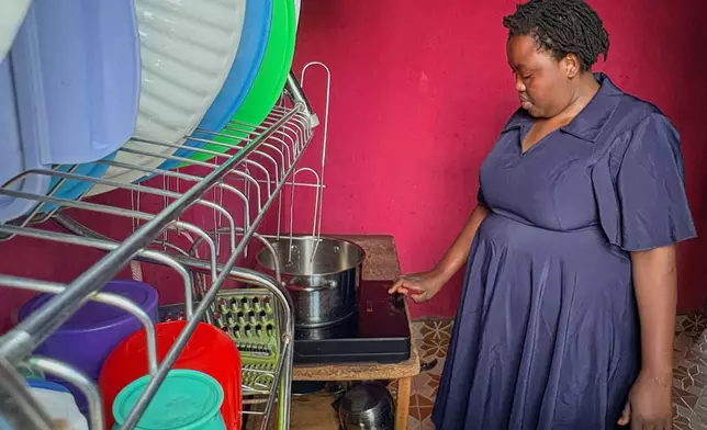 Mary Kavutha prepares breakfast using a fuel-efficient cookstove made by BURN in Kiambu, Kenya, on July 31, 2026. (AP Photo/Allan Olingo)