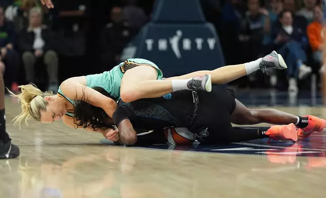 New York Liberty guard Marine Johannes, top, and Minnesota Lynx guard Maya Caldwell, bottom, battle for possession of the ball during the second half of a WNBA basketball game Friday, Sept. 18, 2026, in Minneapolis. (AP Photo/Abbie Parr)