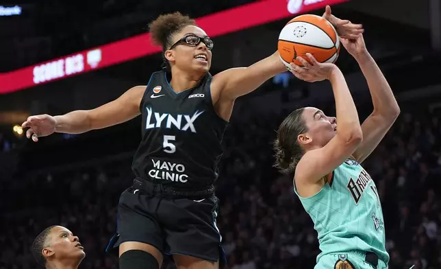 Minnesota Lynx guard Olivia Miles (5) blocks a shot-attempt by New York Liberty guard Pauline Astier, right, during the second half of a WNBA basketball game Friday, Sept. 18, 2026, in Minneapolis. (AP Photo/Abbie Parr)