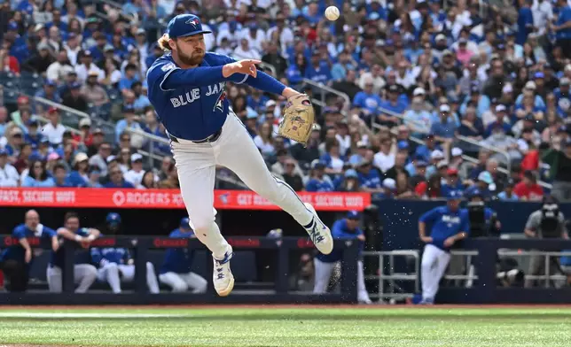 Toronto Blue Jays pitcher Spencer Miles (62) throws to first base after fielding a bunt off the bat of Cincinnati Reds' Carlos Jorge, who was safe, during the third inning of a baseball game in Toronto, Saturday, Sept. 26, 2026. (Jon Blacker/The Canadian Press via AP)