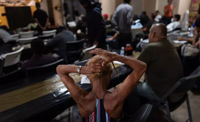 A woman in the audience fixes her hair before the start of Skid Row's inaugural talent show in downtown Los Angeles, Saturday, Sept. 19, 2026. (AP Photo/Jae C. Hong)