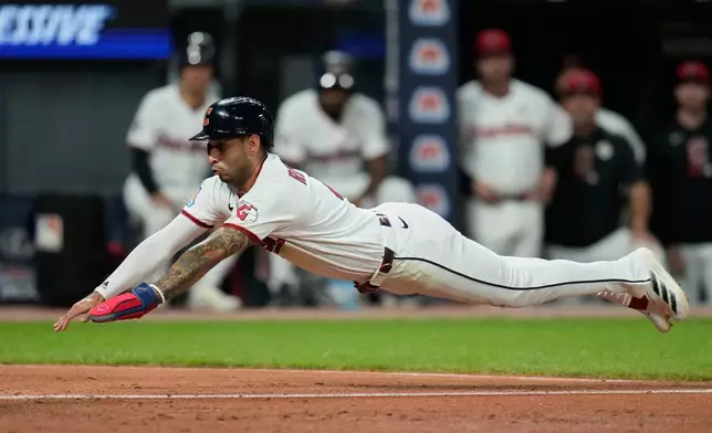 Cleveland Guardians' Brayan Rocchio dives for home plate in the fifth inning of a baseball game against the Chicago White Sox in Cleveland, Tuesday, Sept. 15, 2026. (AP Photo/Sue Ogrocki)