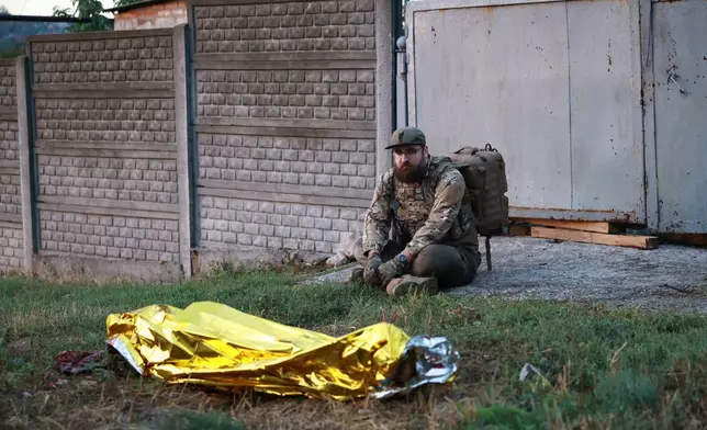 A paramedic looks at the body of a woman killed in a Russian strike on residential neighbourhood on Zaporizhzhia, Ukraine, on Saturday, Sept.26, 2026. (AP Photo/Kateryna Klochko)
