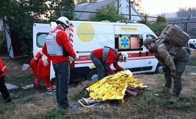 Medics inspect a body of a woman killed in a Russian strike on residential neighbourhood on Zaporizhzhia, Ukraine, on Saturday, Sept.26, 2026. (AP Photo/Kateryna Klochko)