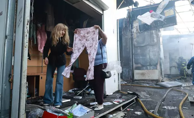 A seller checks clothes at the central market damaged in a Russian strike on Zaporizhzhia, Ukraine, on Saturday, Sept.26, 2026. (AP Photo/Kateryna Klochko)