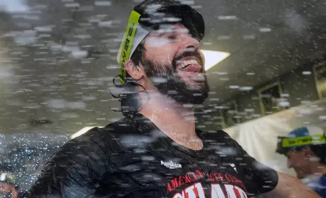 Cleveland Guardians' Austin Hedges celebrates in the clubhouse after clinching the American League Central division title by defeating the Kansas City Royals in a baseball game Saturday, Sept. 26, 2026, in Kansas City, Mo. (AP Photo/Charlie Riedel)