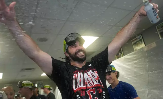 Cleveland Guardians' Austin Hedges celebrates in the clubhouse after clinching the American League Central division title by defeating the Kansas City Royals in a baseball game Saturday, Sept. 26, 2026, in Kansas City, Mo. (AP Photo/Charlie Riedel)