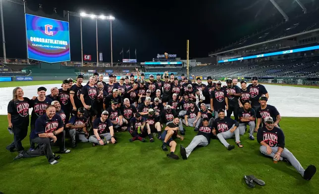 Cleveland Guardians team members celebrate after clinching the American League Central division title by defeating the Kansas City Royals in a baseball game Saturday, Sept. 26, 2026, in Kansas City, Mo. (AP Photo/Charlie Riedel)