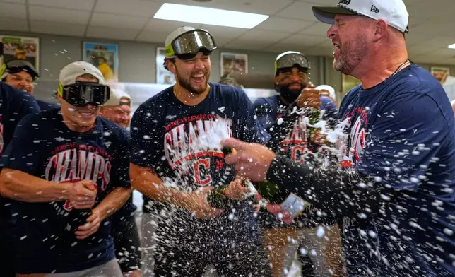 Cleveland Guardians players celebrate with manager Stephen Vogt, rigtht, after clinching the American League Central division title by defeating the Kansas City Royals in a baseball game Saturday, Sept. 26, 2026, in Kansas City, Mo. (AP Photo/Charlie Riedel)