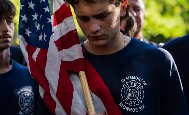 Family of Dennis Cross, a battalion chief who died during 9/11, finish walking 53 miles in Cross' honor as they arrive at the 9/11 Memorial Pools on the 25th anniversary of the September 11 World Trade Center attacks, Friday, Sept. 11, 2026, in New York. (AP Photo/Angelina Katsanis)