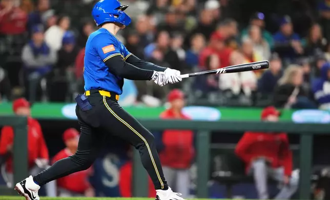 Seattle Mariners' Dominic Canzone follows through on a two-run home run against the Los Angeles Angels during the ninth inning of a baseball game, Friday, Sept. 25, 2026, in Seattle. (AP Photo/Lindsey Wasson)
