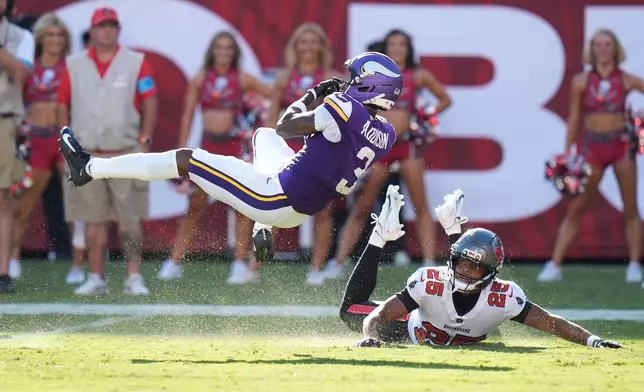 Minnesota Vikings wide receiver Jordan Addison (3) catches a pass for a touchdown as Tampa Bay Buccaneers cornerback Jacob Parrish (25) defends during the first half of an NFL football game in Tampa, Fla., Sunday, Sept. 27, 2026. (AP Photo/Chris O'Meara)