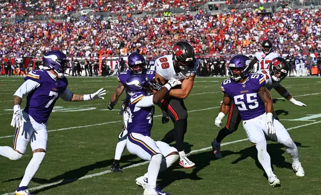 Tampa Bay Buccaneers tight end Cade Otton (88) is tacked by Minnesota Vikings safety Joshua Metellus (44) during the first half of an NFL football game in Tampa, Fla., Sunday, Sept. 27, 2026. (AP Photo/Jason Behnken)