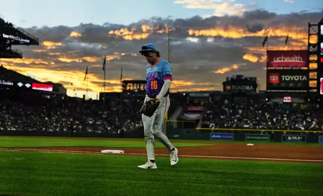 Colorado Rockies center fielder Cole Carrigg heads to the dugout after the top of the third inning of a baseball game against the Seattle Mariners, Friday, Sept. 18, 2026, in Denver. (AP Photo/David Zalubowski)