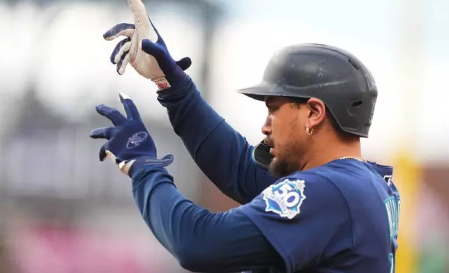Seattle Mariners' Josh Naylor gestures to the dugout after reaching first base on a two-run single off Colorado Rockies starting pitcher Gabriel Hughes in the first inning of a baseball game Friday, Sept. 18, 2026, in Denver. (AP Photo/David Zalubowski)