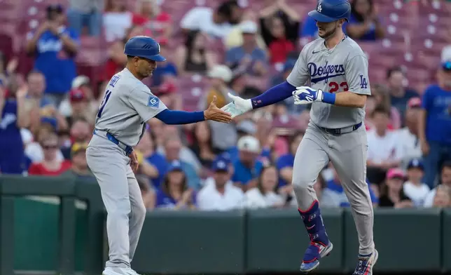 Los Angeles Dodgers right fielder Kyle Tucker, (23) celebrates with third base coach Dino Ebel (91) as he rounds third base after hitting a solo home run during the second inning of a baseball game against the Cincinnati Reds, Monday, Sept. 14, 2026, in Cincinnati. (AP Photo/Carolyn Kaster)