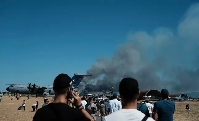 Spectators watch as smoke rises after a Hellenic Air Force F-4 Phantom fighter jet crashed, during the Athens Flying Week airshow at Tanagra Air Force Base, north of Athens, Greece, Saturday, Sept. 5, 2026. (AP Photo/Kallista Allaway)