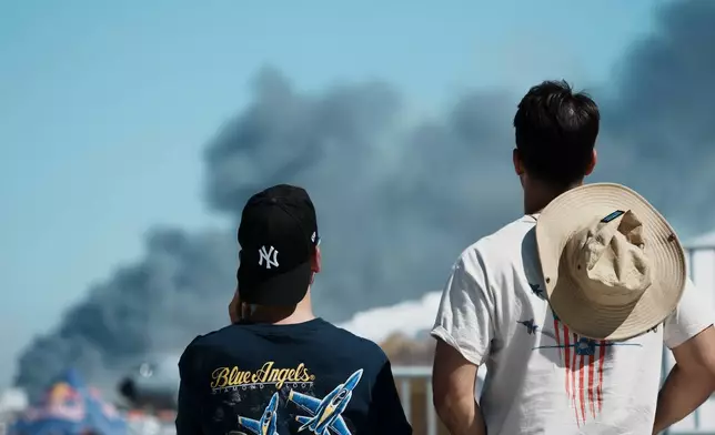 Spectators watch as smoke rises after a Hellenic Air Force F-4 Phantom fighter jet crashed, during the Athens Flying Week airshow at Tanagra Air Force Base, north of Athens, Greece, Saturday, Sept. 5, 2026. (AP Photo/Kallista Allaway)