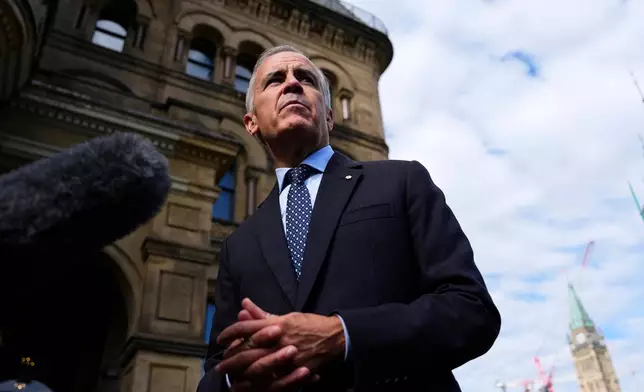 Canadian Prime Minister Mark Carney speaks with members of the media as he arrives at the Office of the Prime Minister and Privy Council in Ottawa, on Tuesday, Sept. 1, 2026. (Justin Tang/The Canadian Press via AP)