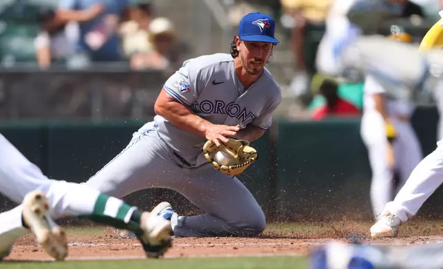 Toronto Blue Jays pitcher Michael Lorenzen, fields the ball after a wild pitch resulting in a run for the Athletics during the fourth inning of a baseball game Wednesday, Sept. 9, 2026, in West Sacramento, Calif. (AP Photo/Scott Marshall)