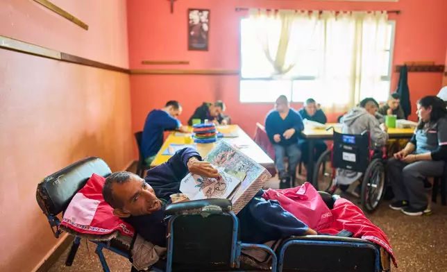 Raul colors an illustration of Spiderman in a painting workshop at the Pequeño Cottolengo Don Orione, a home for people with disabilities that will be visited by Pope Leo XIV in November, in Buenos Aires, Argentina, Thursday, Sept. 24, 2026. (AP Photo/Rodrigo Abd)
