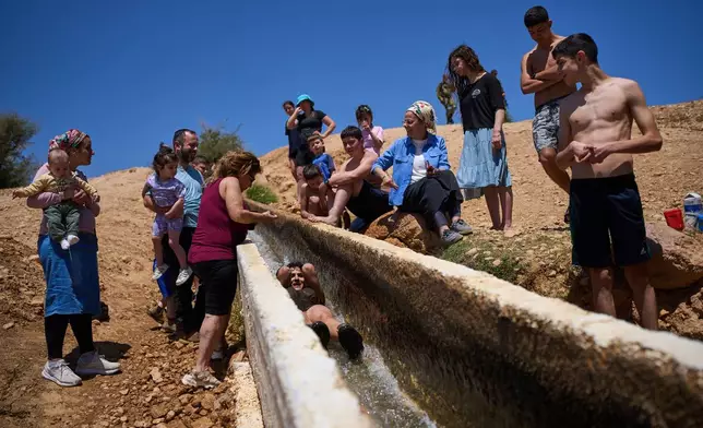 Israelis enjoy a day at a spring in Auja, in the Jordan Valley, during Israel's Independence Day on April 22, 2026, in the occupied West Bank. (AP Photo/Ohad Zwigenberg)