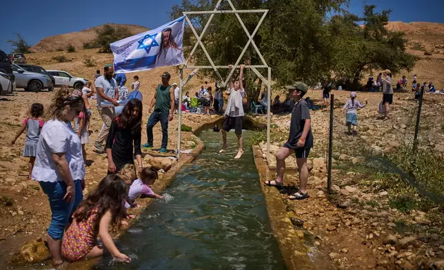 A child climbs on a metal Star of David structure at a spring in Auja, in the Jordan Valley, during Israel's Independence Day on April 22, 2026, in the occupied West Bank. (AP Photo/Ohad Zwigenberg)